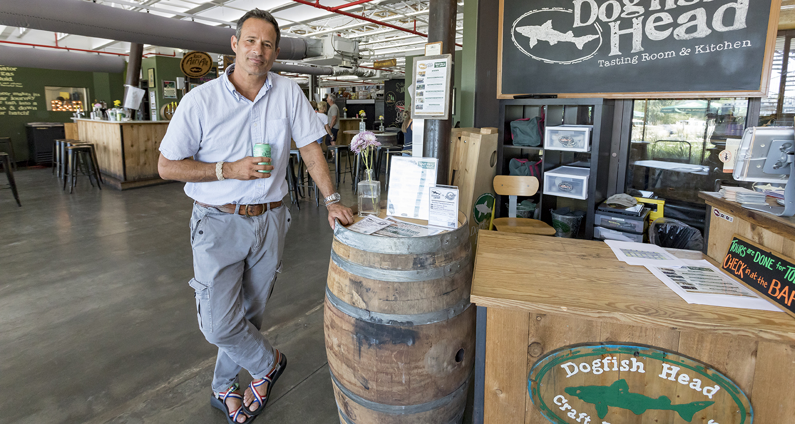 Sam Calagione '92 leaning against brew barrel at Dogfish Head brewery.